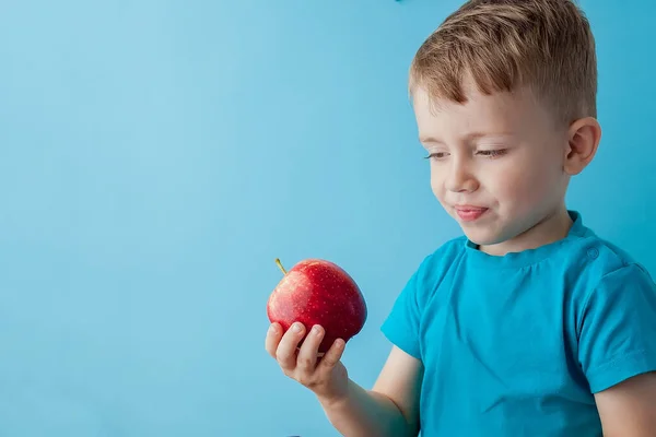 Дитина Тримає Їсть Червоне Яблуко Синьому Фоні Їжу Дієту Концепцію — стокове фото