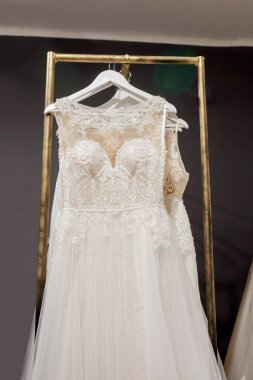 Ürün yelpazesine bir askı arka plan stüdyo üzerinde asılı elbiseler. Moda düğün trendleri. Düğün salonu iç.