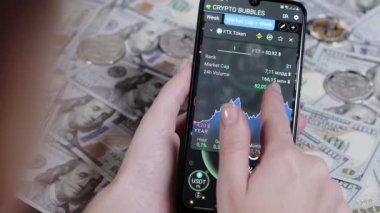 Kripto para çiftleri. Kabarcık Çizelgesi, Grafik. Faiz, endeks, düşüş, büyüme, mobil bir uygulamanın akıllı telefon ekranındaki numaralar. Komisyoncu ekrana parmağıyla dokunur, FTX finansal göstergelerini analiz eder.