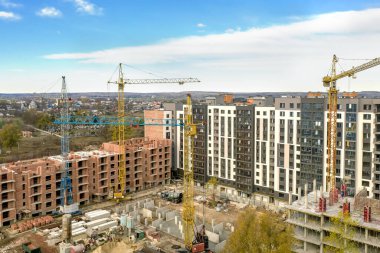 Yeni bir çok katlı konut kompleksi inşa ediliyor. Vinçler ve inşaat alanı. Modern apartmanlar inşa ediliyor..