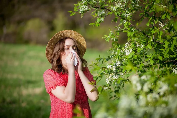 Młoda Kobieta Dmuchająca Nos Kichająca Chusteczkę Przed Kwitnącym Drzewem Alergeny — Zdjęcie stockowe
