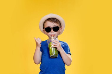 Sarı Stüdyo Üzerindeki Plastik Kupa 'dan Mojito kokteyli içen tatlı çocuk..
