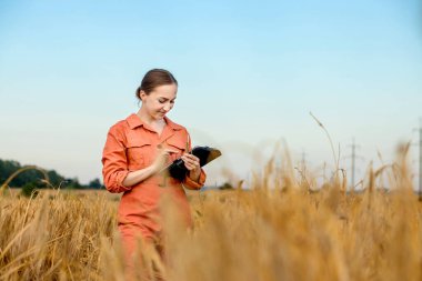 Buğday tarlasında tablet bilgisayarlı beyaz tenli teknoloji uzmanı kadın tarım için ürün kalitesini ve büyümesini kontrol ediyor. Buğday testi kavramı.