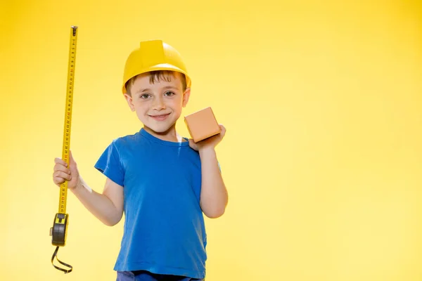 Boy Construction Helmet Holds Brick His Hands Measures Tape Measure — Fotografia de Stock