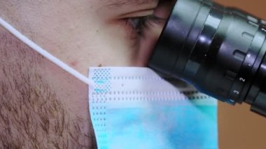 Mikroskopla araştırma yapan genç bir bilim adamı. Mikroskopla çalışmak.