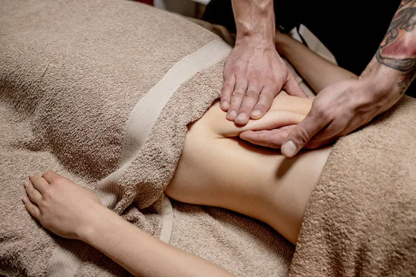 Close up of therapist doing stomach massage on woman in spa — Stock Photo, Image