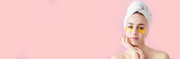 Retrato de Mulher Beleza com manchas nos olhos sobre fundo rosa. Cara de beleza de mulher com máscara sob os olhos. Mulher bonita com maquiagem natural e remendos de colágeno de cosméticos dourados na pele facial fresca — Fotografia de Stock