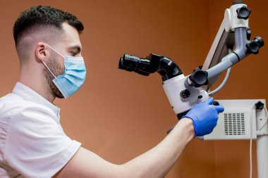 Mikroskopla araştırma yapan genç bir bilim adamı. Mikroskopla çalışmak.