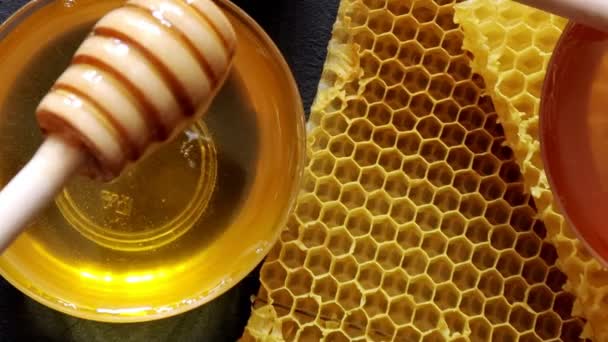 蜂蜜滴着 从木勺里倒出来 液体新鲜的金黄色蜂蜜 Honeycombs 健康的有机蜂蜜 — 图库视频影像