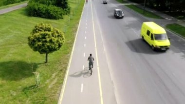Güneşli bir günde bisiklet yolunda bisiklet süren genç bir adam. Güneşli bir yaz gününde atletizm ya da dayanıklılık eğitimi. Sağlıklı bisiklet yaşam tarzı.