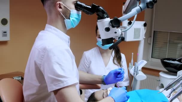 Tandarts Kijkt Door Een Microscoop Naar Tanden Van Patiënt Moderne — Stockvideo