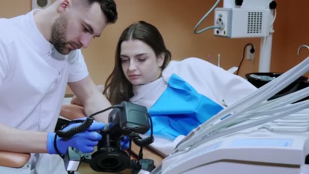 Dokter Gigi Menunjukkan Kepada Pasien Gambar Dari Hasil Pengobatan Pasien — Stok Video