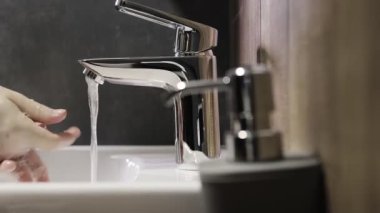 Kadın şeker kutusunu itiyor ve sıvı sabun eline sıkışıyor. Kadınlar tuvalette ellerini yıkamak için gelişmiş cilt bakımı ve dezenfeksiyon için hafif bir jel kullanıyor..