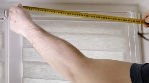 Handyman Tape Measure Installs White Roller Blinds Indoors Shutters Day — Stock Video