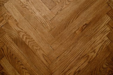 Koyu kahverengi Noel ağacı şeklinde klasik bir meşe parke. Kahverengi, pürüzsüz parke zemin. Dar tahtalardan alacalı ladin deseni..