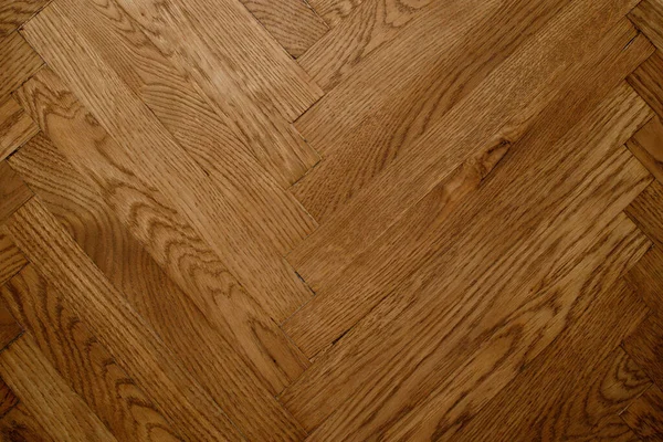 Koyu kahverengi Noel ağacı şeklinde klasik bir meşe parke. Kahverengi, pürüzsüz parke zemin. Dar tahtalardan alacalı ladin deseni..