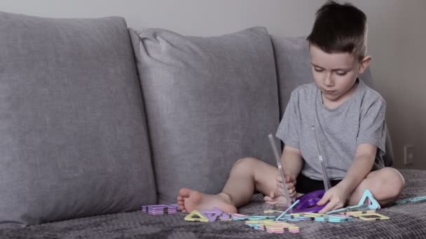 Een Jongen Een Grijs Shirt Zit Een Bed Buurt Van — Stockvideo