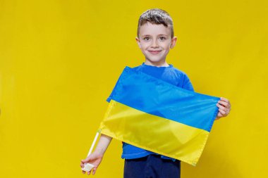 Sarı ve mavi bayrak taşıyan, Ukrayna bayrağı taşıyan küçük bir çocuk. Çocuk Ukrayna bayrağını göstererek Ukrayna 'yı destekleyecek. Rus saldırısı Ukrayna 'da. Savaşa karşı çocuklar.