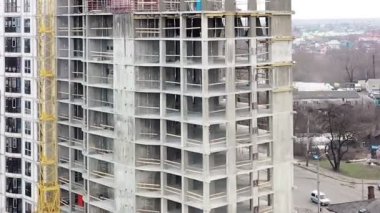 Bir şehirde inşaat halindeki yüksek apartmanın beton çerçevesinin havadan görünüşü.