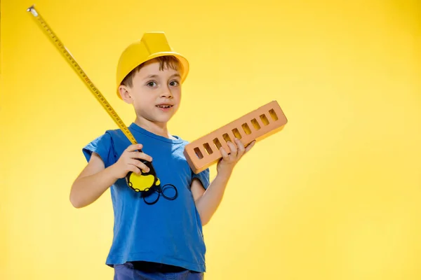 Boy Construction Helmet Holds Brick His Hands Measures Tape Measure — Fotografia de Stock