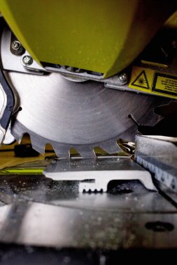 Kurulmadan önce dairesel testerenin süpürgeliğini kesen işçiler.