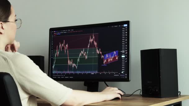 Woman trader trades and analyzes the cryptocurrency market, invests money while sitting in a home — Vídeos de Stock