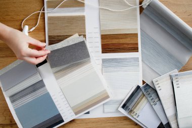 Kumaş perdeleri için kumaş seçimi için katalog şeklinde farklı doku ve renk örnekleri. Gece gündüz kör örnekleri.