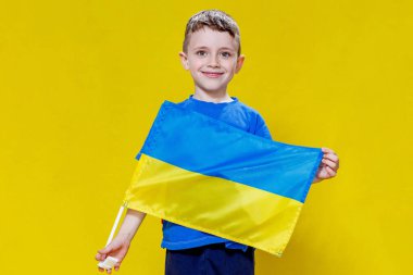 Sarı ve mavi bayrak taşıyan, Ukrayna bayrağı taşıyan küçük bir çocuk. Çocuk Ukrayna bayrağını göstererek Ukrayna 'yı destekleyecek. Rus saldırısı Ukrayna 'da. Savaşa karşı çocuklar.