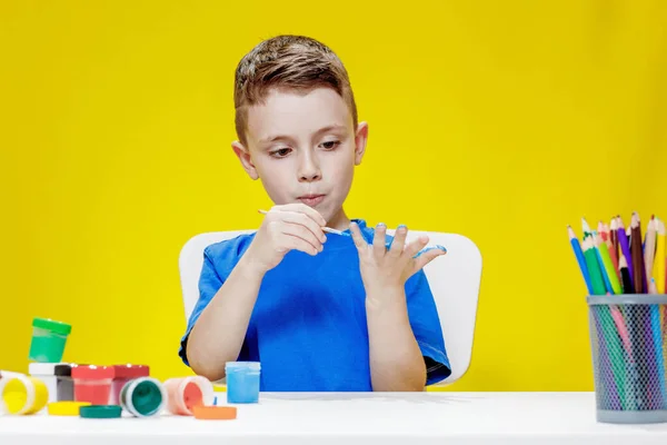 Little Preschooler Sits Table Holding Brush His Hand Painting Paints — Fotografia de Stock