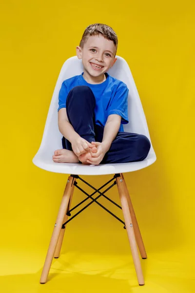 Niño Alegre Una Camiseta Casual Azul Pantalones Sentados Una Silla —  Fotos de Stock