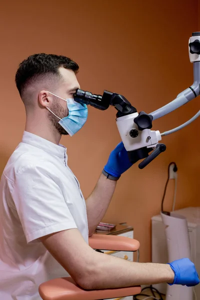 Dentysta Patrzy Mikroskop Nowoczesna Stomatologia Wykorzystująca Nowe Technologie — Zdjęcie stockowe