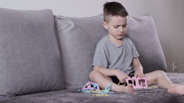 Manyetik inşaatçıyla oynayan küçük bir çocuk. Yaratıcılık gelişimi. Manyetik yapıcı.