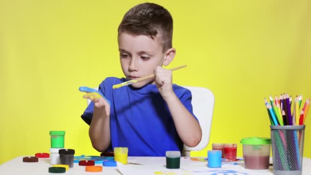 Little Preschooler Sits Table Holding Brush His Hand Painting Paints — стоковое видео