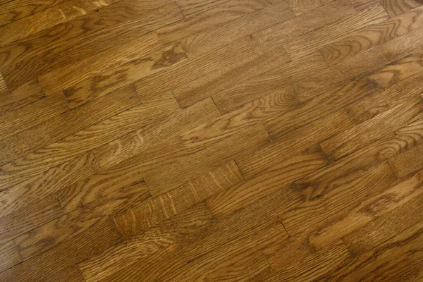 Classic wooden oak parquet in the form of a dark brown Christmas tree. Brown seamless parquet floor with a pattern of spruce from narrow boards.