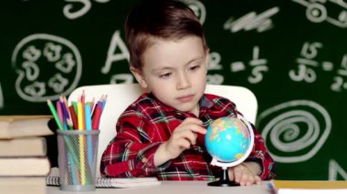 Küreye bakan çocuklar için evde eğitim. Bir çocuk evde küreyi inceliyor. Bir çocuğa öğretmek