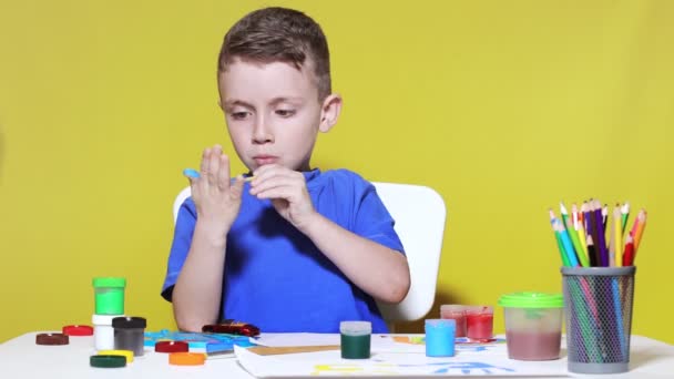 Little Preschooler Sits Table Holding Brush His Hand Painting Paints — Video Stock