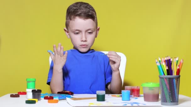 Little Preschooler Sits Table Holding Brush His Hand Painting Paints — Vídeo de stock