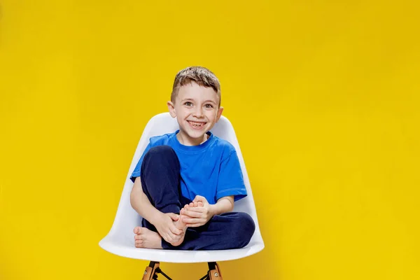 Cheerful Little Boy Blue Casual Shirt Pants Sitting White Chair — Fotografia de Stock