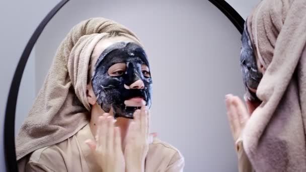 Jonge Vrouw Die Gezichtsmasker Aanbrengt Badkamer Glimlacht Mooie Vrouw Voorkant — Stockvideo