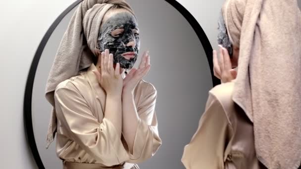 수건을 여성은 욕실에서 마스크를 만들고 거울을 여자는 피부를 이하기 — 비디오