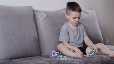 Manyetik inşaatçıyla oynayan küçük bir çocuk. Yaratıcılık gelişimi. Manyetik yapıcı.