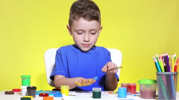 Seorang Anak Sedang Duduk Meja Menggambar Dengan Telapak Tangannya Atas — Stok Video