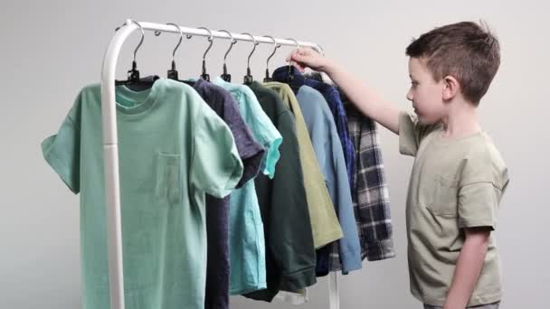 Мальчик Дошкольник Стоит Вешалок Собирает Одежду Выбирает Одежду Сегодня — стоковое видео