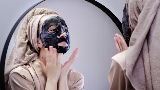 Jonge Vrouw Die Gezichtsmasker Aanbrengt Badkamer Glimlacht Mooie Vrouw Voorkant — Stockvideo