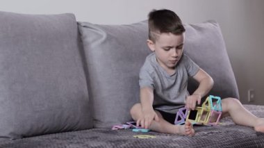 Manyetik inşaatçıyla oynayan küçük bir çocuk. Yaratıcılık gelişimi. Manyetik yapıcı.