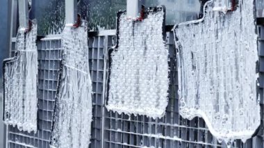 Basınç altında su sağlayan bir hortumla plastik araba halılarını yıkamak..