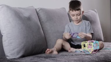 Manyetik inşaatçıyla oynayan küçük bir çocuk. Yaratıcılık gelişimi. Manyetik yapıcı.