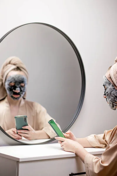 Kvinna Framför Spegel Applicerar Fuktgivande Mask För Att Vårda Ansiktshud — Stockfoto