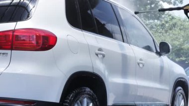 Araba yıkamada yüksek basınç altında arabayı köpük ve suyla yıkamak. Araba yıkama konsepti. Köpüklü araba..