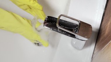 Eldivenli kadınlara yakın lavabo ve lavabo temizleyicileri. Ev temizliği kavramı.